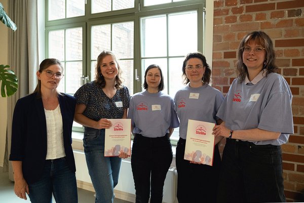 5 Frauen stehen nebeneinander und schauen in die Kamera