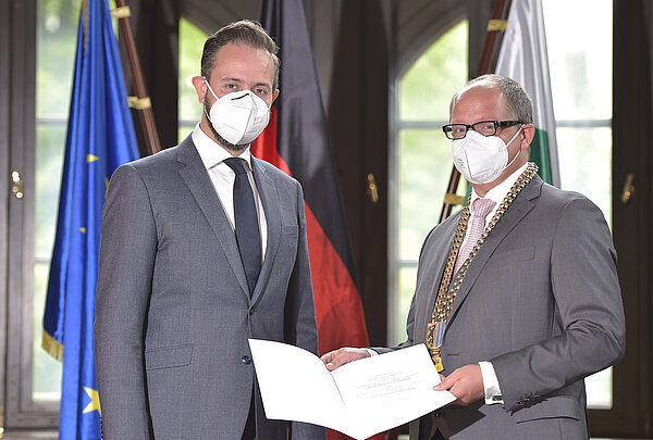 Wissenschaftsminister Sebastian Gemkow und HTWK-Rektor Prof. Mark Mietzner. (Foto: Matthias Rietschel) Zwei Männer feierlich mit Maske und Urkunde