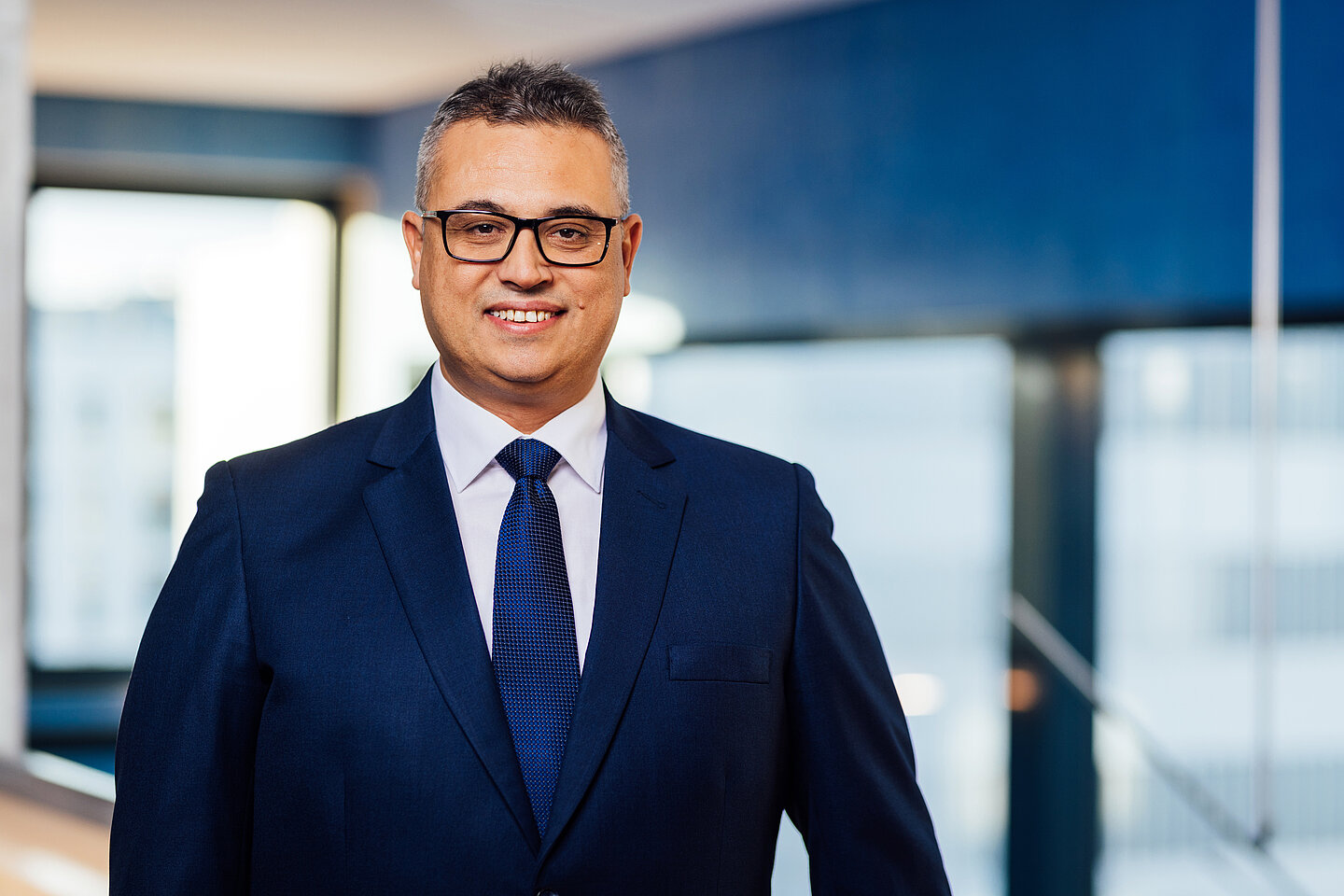 Portrait des Prorektors für Forschung und Nachhaltigkeit der HTWK Leipzig: Prof. Faouzi Derbel Lächelnder Faouzi Derbel in der Hochschulbibliothek