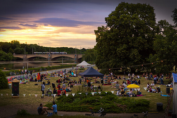 Hörspielsommer 2020. (Foto: Hörspielsommer e.V. Tino Pfundt) Totale: Abendliche Stimmung mit vielen Menschen auf einer Wiese