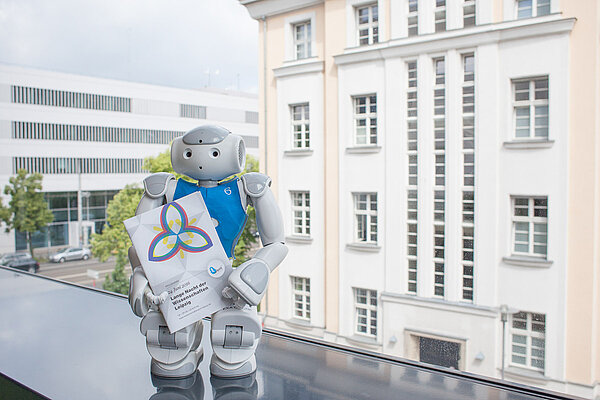 Nao-Team HTWK bei der Wissenschaftsnacht (Foto: Kristina Denhof) Ein Nao-Roboter hält das Programmheft zur Langen Nacht der Wissenschaften